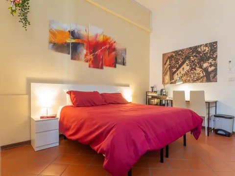 Schlafzimmer mit rotem Bett und Nachttischen