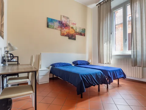 Schlafzimmer mit blauem Bett und Schreibtisch